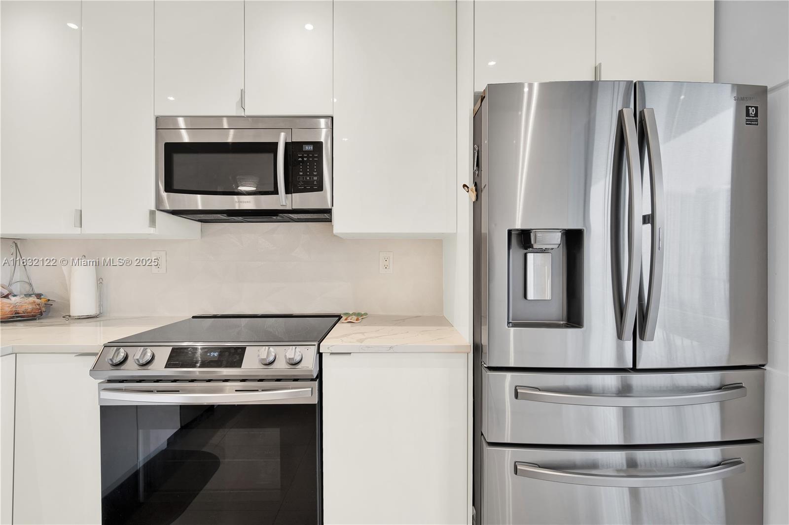 521 North Riverside Drive, Unit 707 Pompano Beach, FL 33062 - Photo 6 of 50 a kitchen with stainless steel appliances a refrigerator sink and microwave