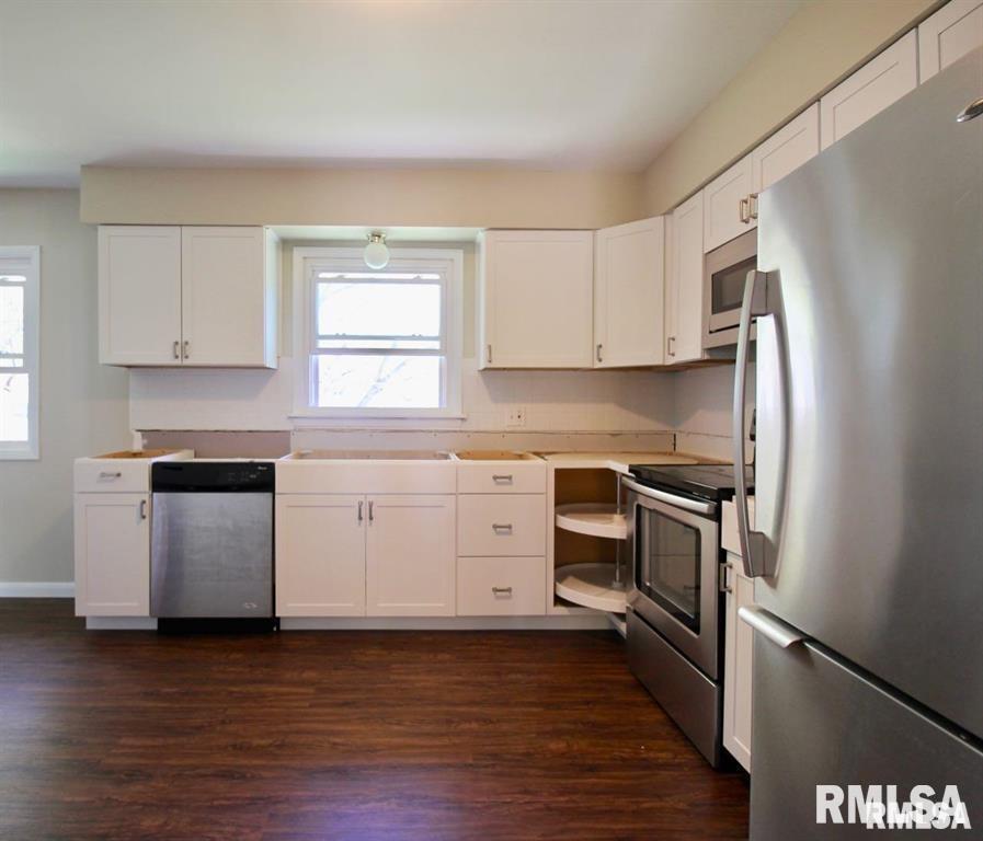 3218 Fairhaven Road Davenport, IA 52807 - Photo 2 of 7 a kitchen with a refrigerator stove and white cabinets