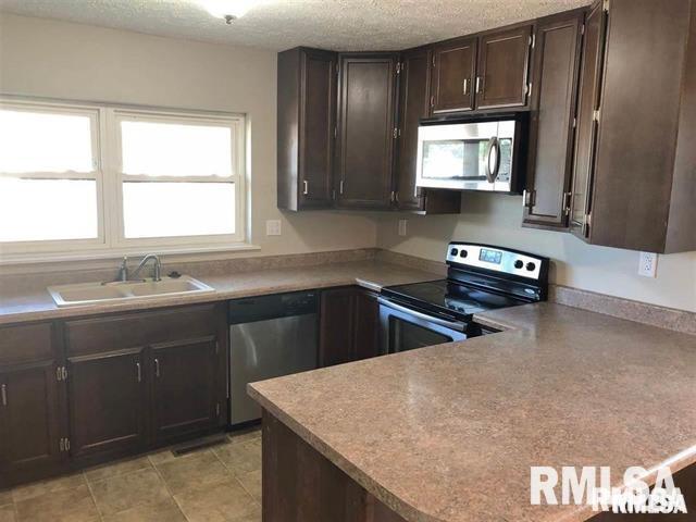 3218 Fairhaven Road Davenport, IA 52807 - Photo 4 of 7 a kitchen with stainless steel appliances granite countertop a sink a stove and a microwave
