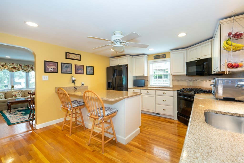 357 Webster Street Needham, MA 02494 - Photo 5 of 30 a large kitchen with stainless steel appliances granite countertop a stove a sink a dining table and chairs with wooden floor