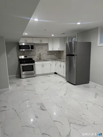 a kitchen with stainless steel appliances a refrigerator and a stove top oven