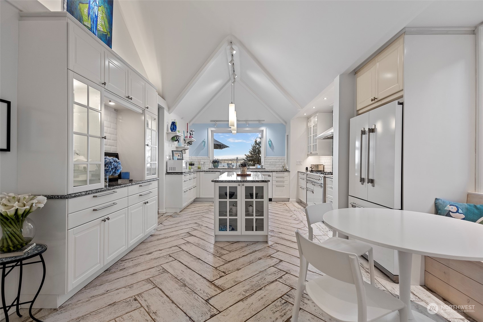 4903 Saratoga Road Langley, WA 98260 - Photo 13 of 40 a large white kitchen with cabinets a sink a window and stainless steel appliances
