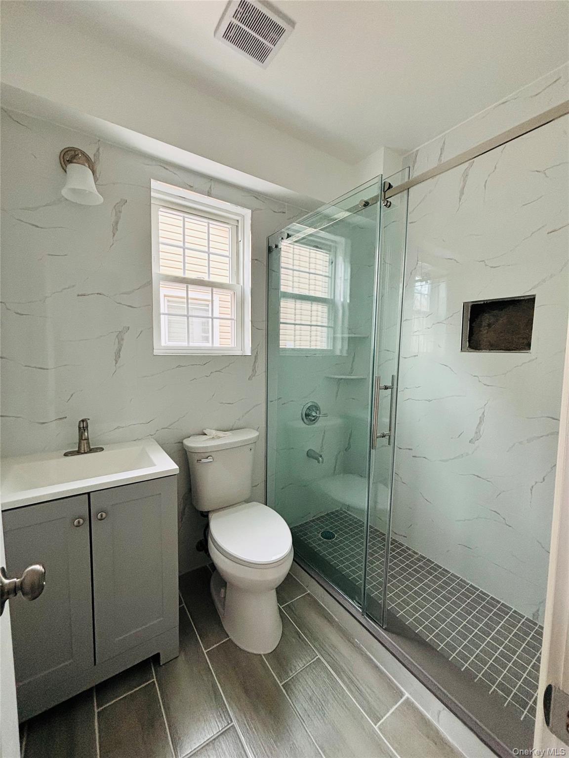104-39 210th Street Queens, NY 11429 - Photo 15 of 18 a bathroom with a sink toilet a mirror and shower