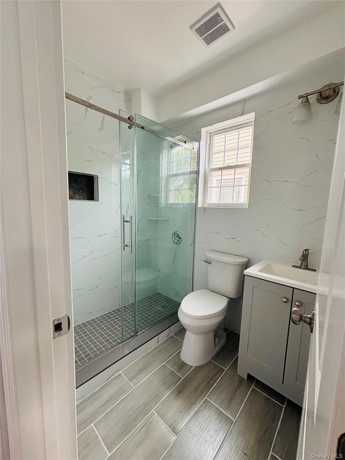 104-39 210th Street Queens, NY 11429 - Photo 17 of 18 a bathroom with a toilet sink and shower