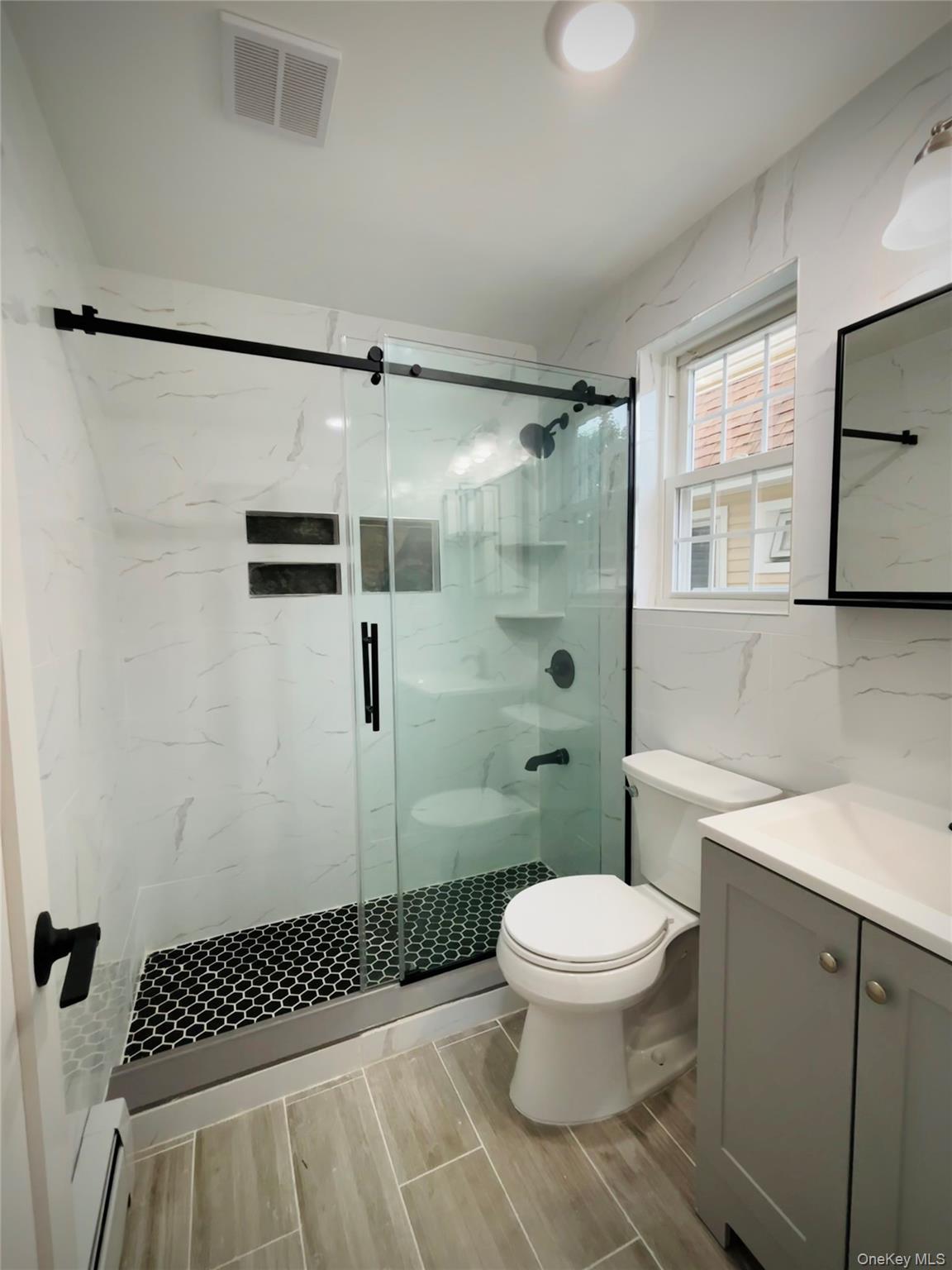 104-39 210th Street Queens, NY 11429 - Photo 7 of 18 a bathroom with a toilet a sink and shower