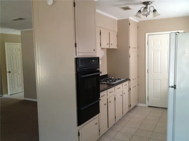 a kitchen with granite countertop a stove and a refrigerator
