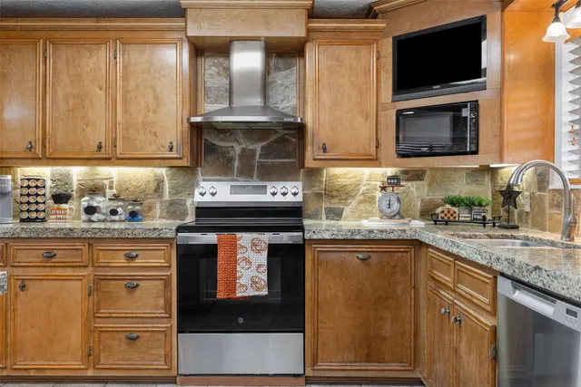 a kitchen with stainless steel appliances granite countertop a stove and a microwave