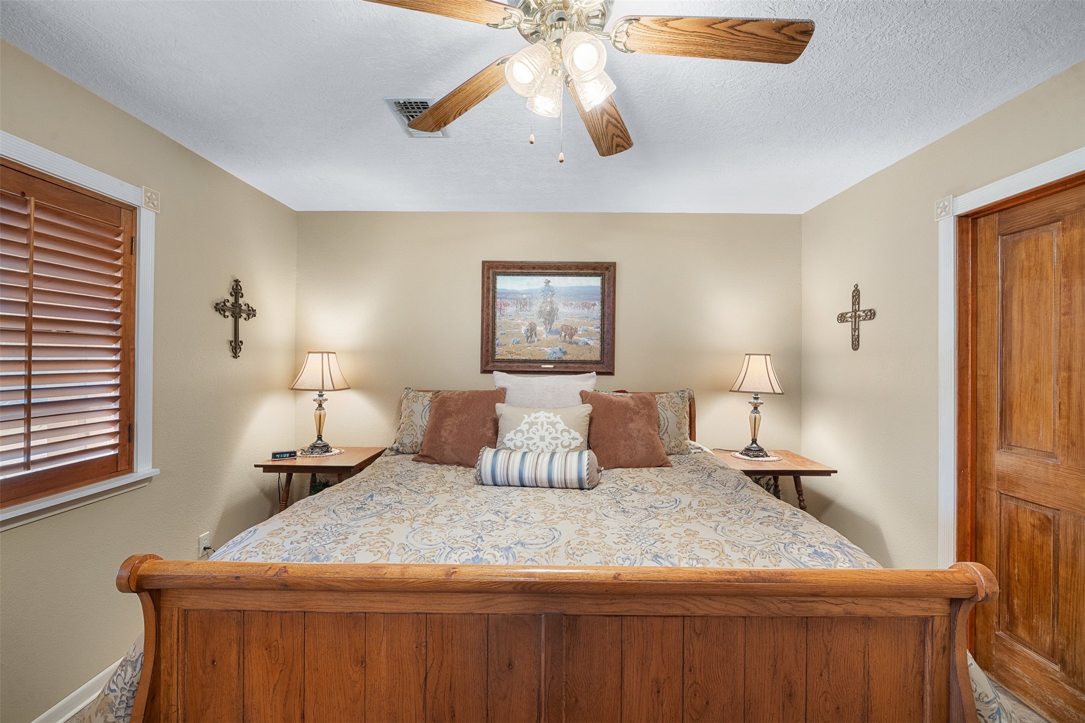 1611 Koy Road Bellville, TX 77418 - Photo 19 of 44 a bedroom with a large bed and a chandelier