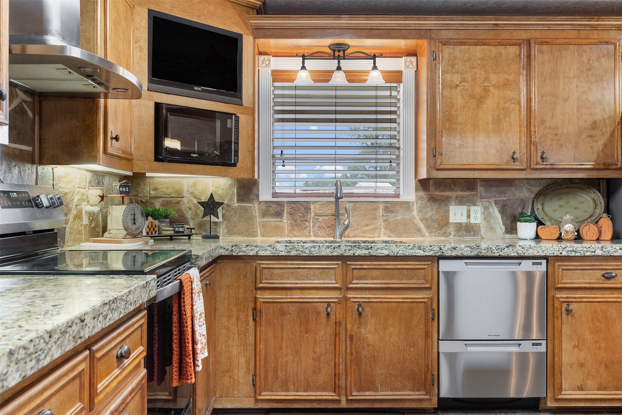 1611 Koy Road Bellville, TX 77418 - Photo 10 of 44 a kitchen with granite countertop a sink and a stove top oven