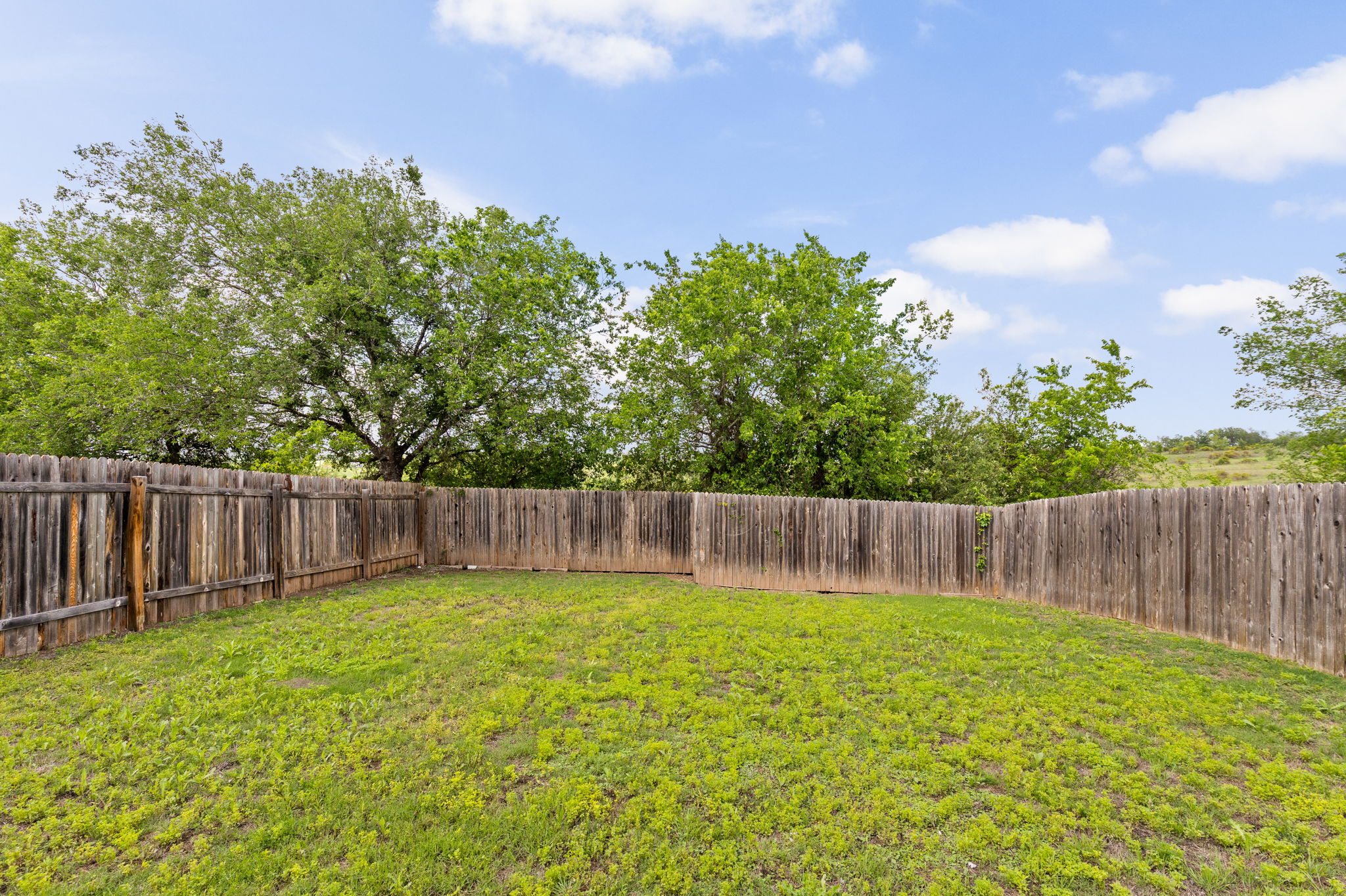 6702 Routenburn Street Austin, TX 78754 - Photo 23 of 24 a view of backyard with a small cabin and wooden fence