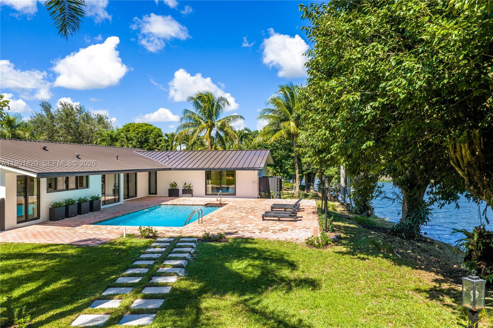 10945 Southwest 75th Court Pinecrest, FL 33156 - Photo 6 of 81 a front view of a house with a yard