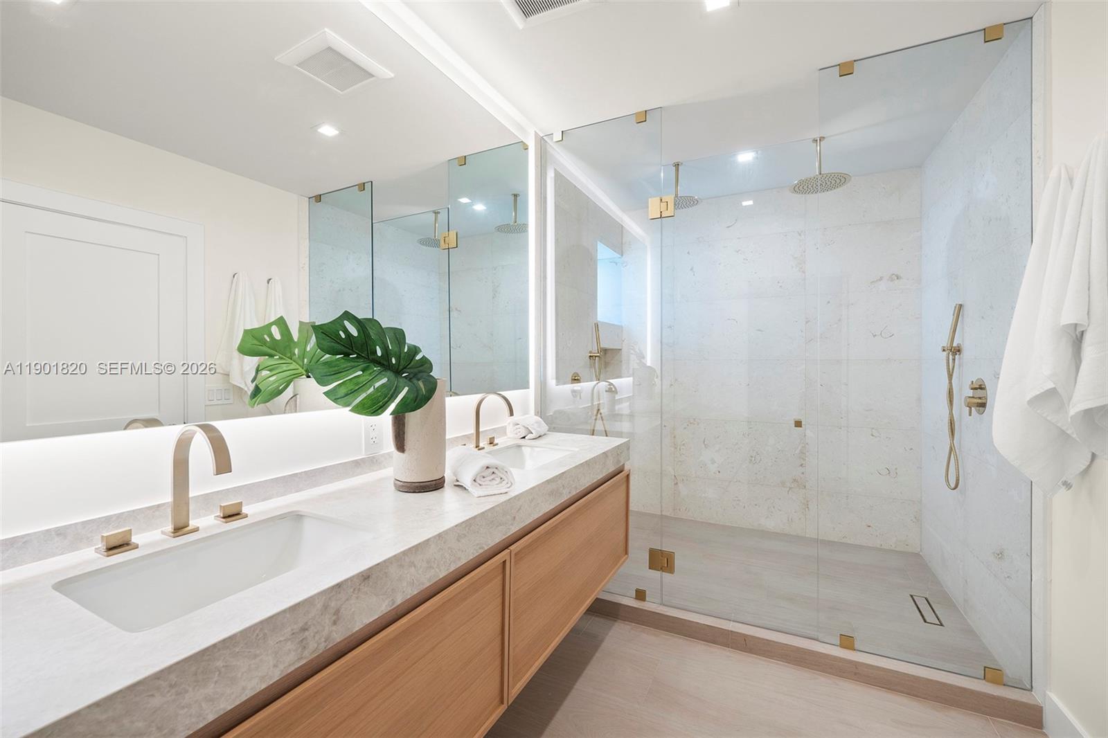 10945 Southwest 75th Court Pinecrest, FL 33156 - Photo 63 of 81 a bathroom with a double vanity sink mirror and shower