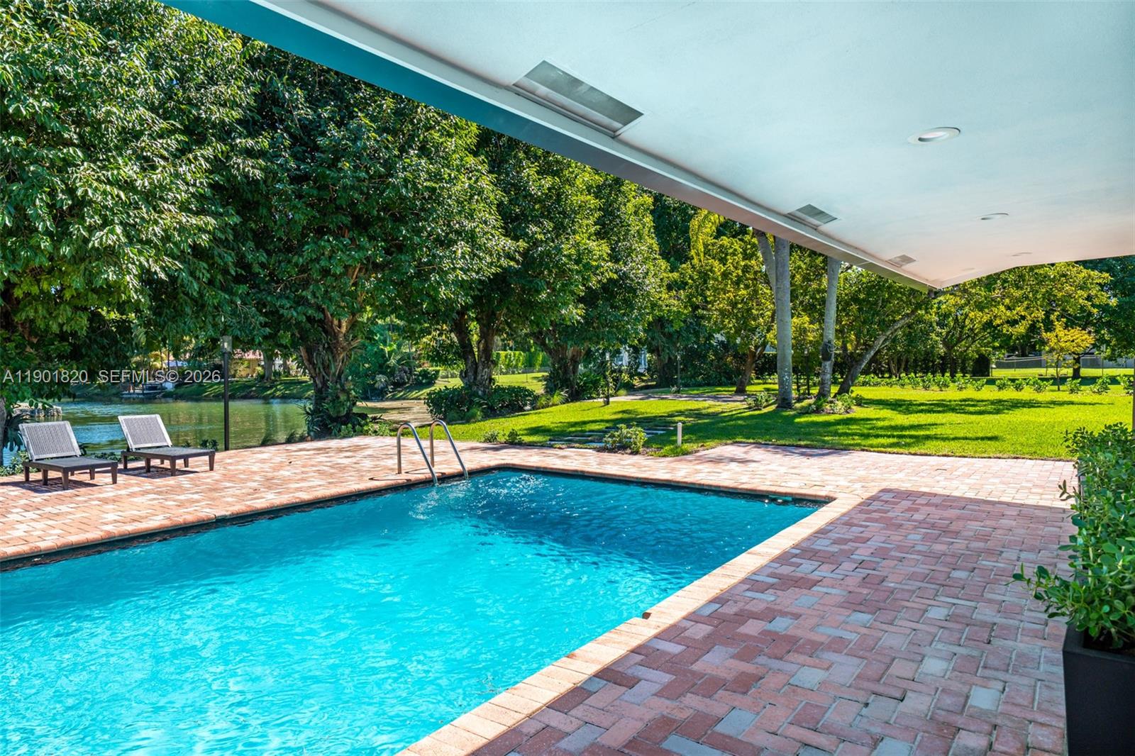 10945 Southwest 75th Court Pinecrest, FL 33156 - Photo 73 of 81 a view of a swimming pool with a porch
