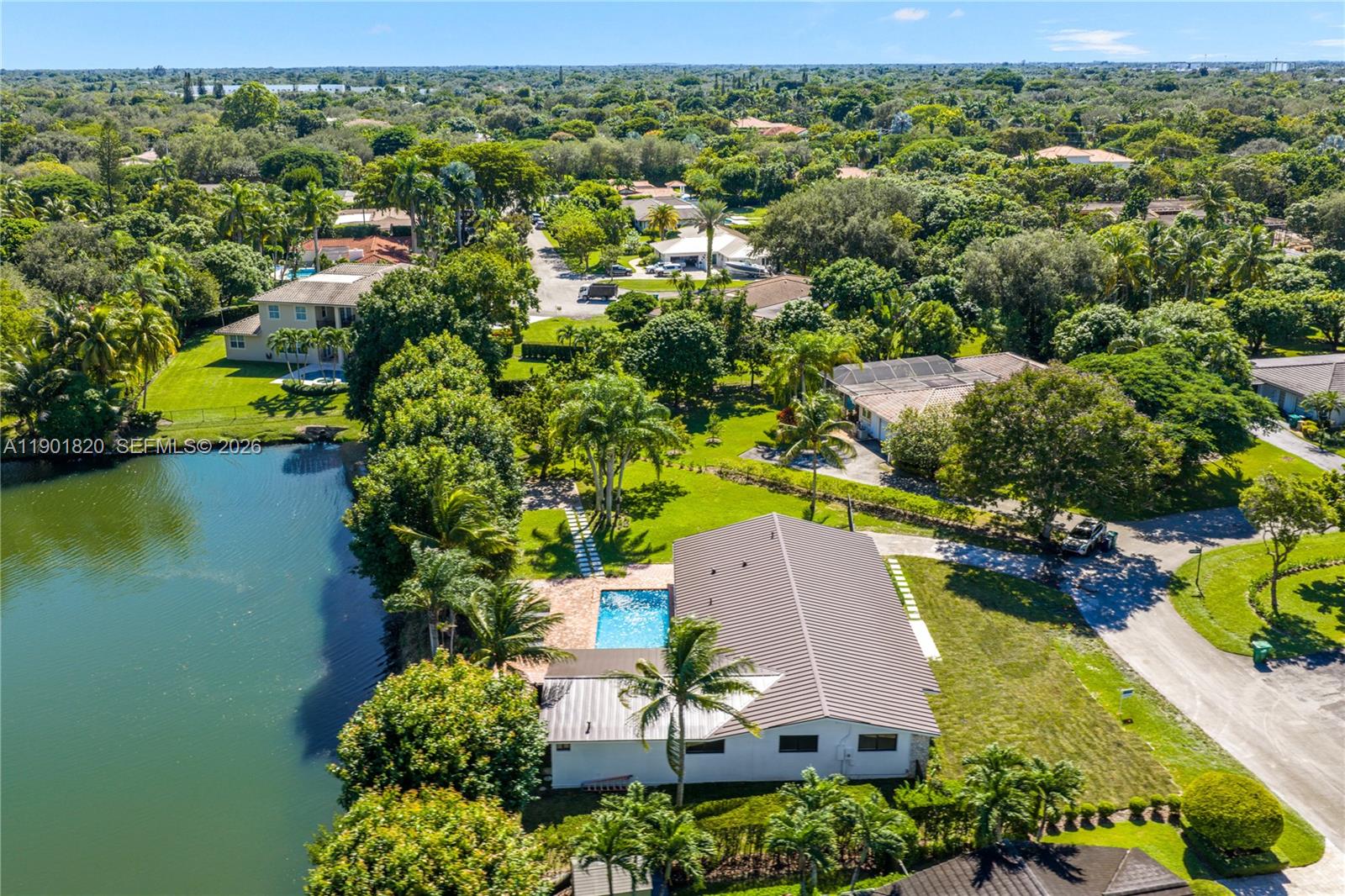 10945 Southwest 75th Court Pinecrest, FL 33156 - Photo 78 of 81 an aerial view of a house with a garden and lake view