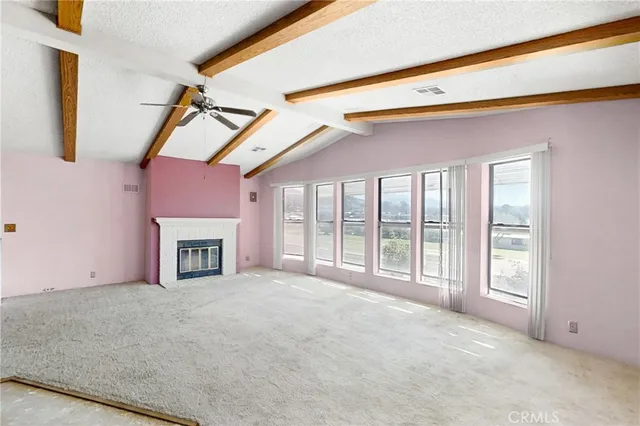 a view of an empty room with a fireplace and a window