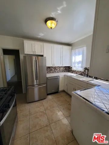 a kitchen with a sink a refrigerator and a stove