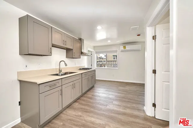 a kitchen with a sink cabinets stainless steel appliances and a window