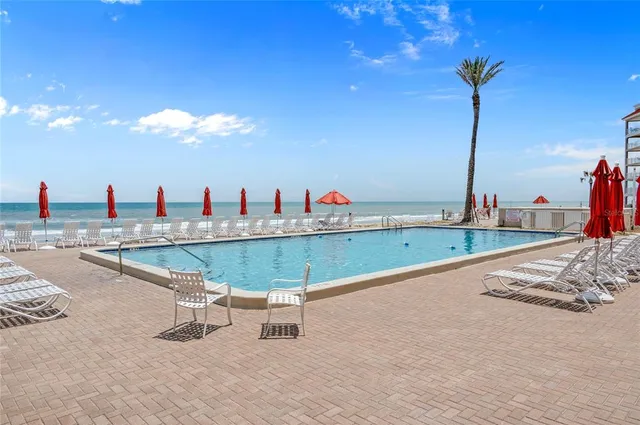 a view of a tall building with a lawn chairs and a fountain