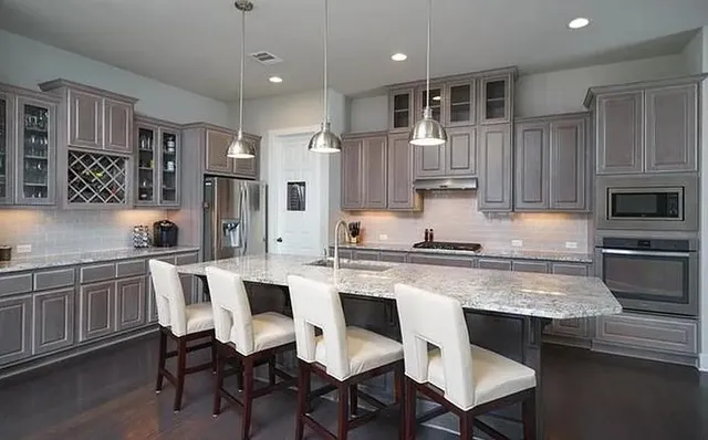 a kitchen with a stove center island wooden floor and a large window