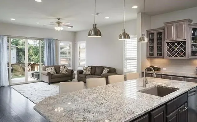 a kitchen with stainless steel appliances granite countertop a stove a sink dishwasher a stove and a refrigerator with wooden floor