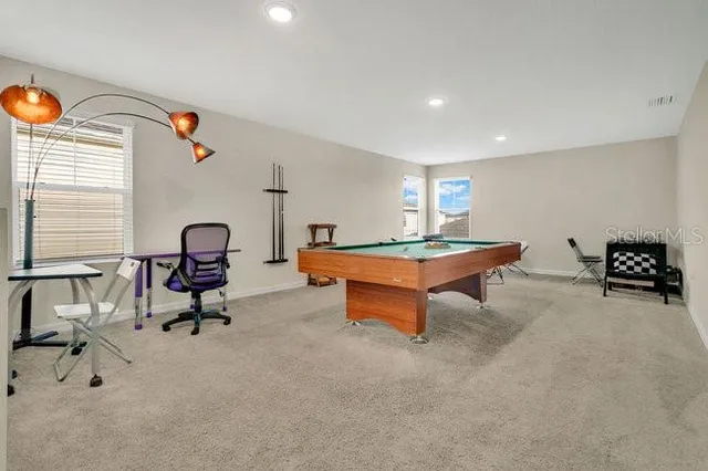 a living room with furniture a rug and gym equipment