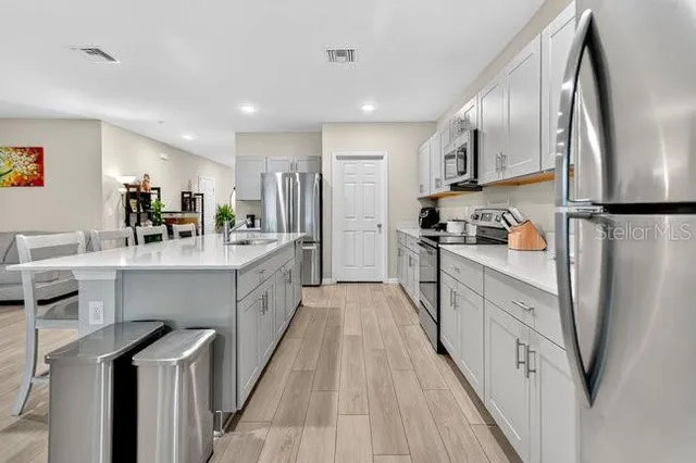 a kitchen with stainless steel appliances a refrigerator sink and cabinets