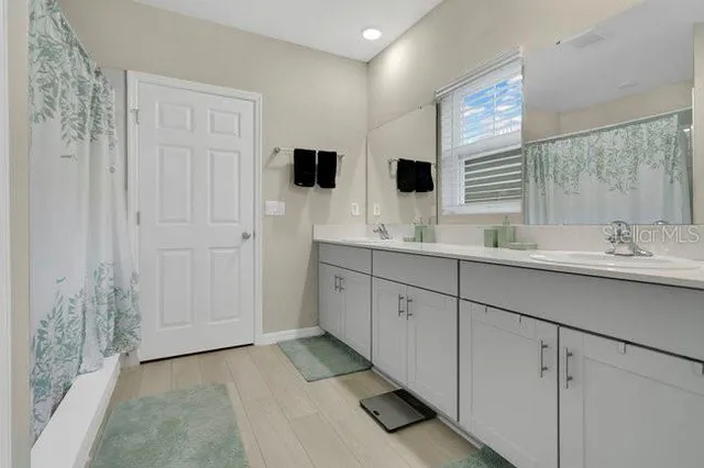 a spacious bathroom with double vanity and a mirror