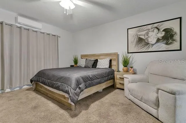 a spacious bedroom with a bed and a painting on the wall