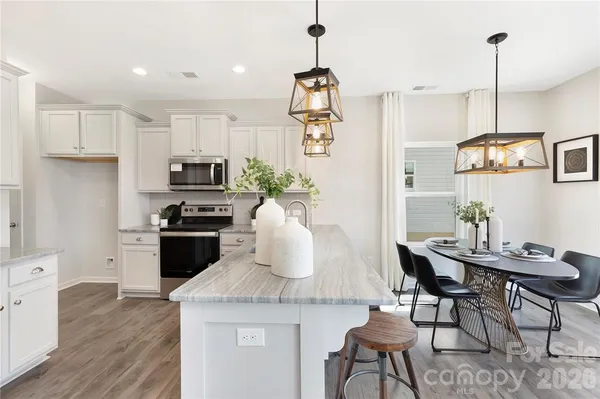 a kitchen with granite countertop white cabinets and stainless steel appliances