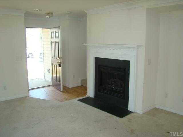 2627 Quarry Springs Road Raleigh, NC 27610 - Photo 4 of 9 a view of an empty room with a fireplace and a window
