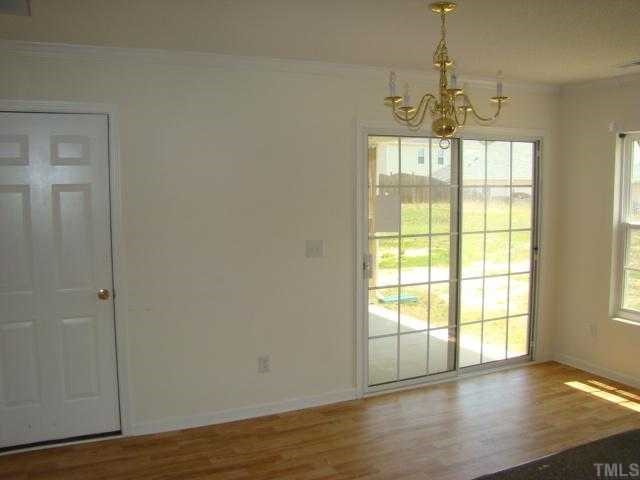 2627 Quarry Springs Road Raleigh, NC 27610 - Photo 6 of 9 a view of an empty room with wooden floor and a window