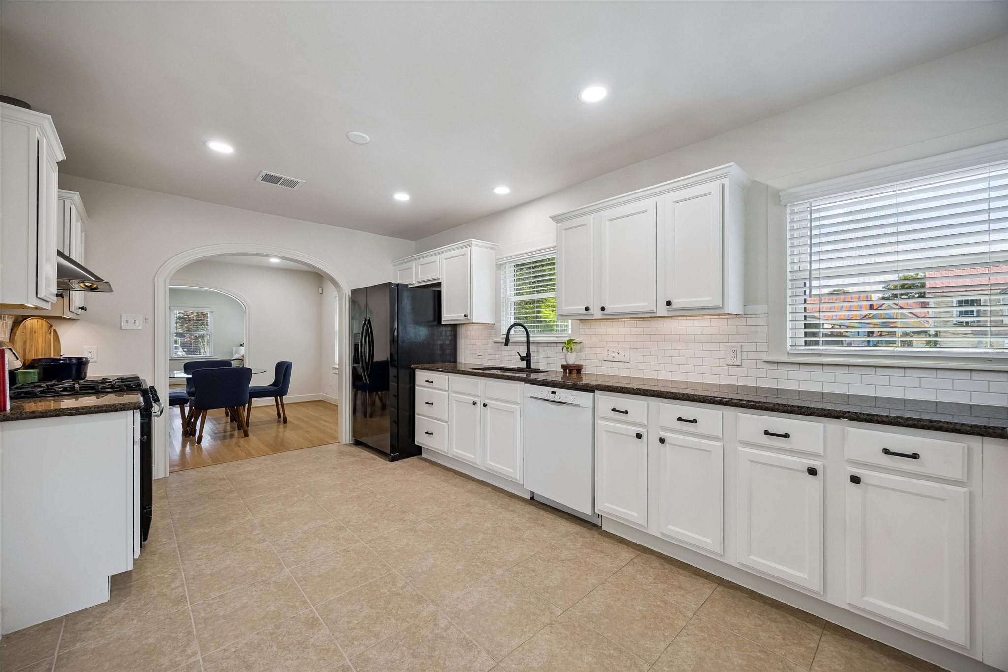 809 Gale Street Houston, TX 77009 - Photo 8 of 18 Spacious kitchen offering white cabinetry, granite countertops, subway tile backsplash, and generous workspace.