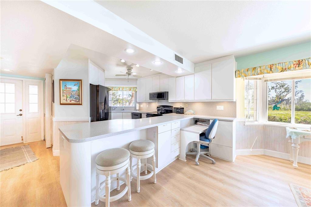 11000 Placida Road, Unit 101 Placida, FL 33946 - Photo 12 of 22 a kitchen with a dining table chairs and a large window