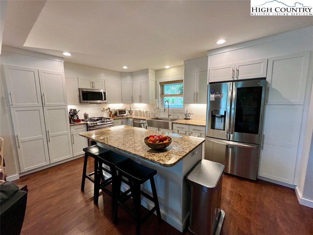 366 Russelton Road Boone, NC 28607 - Photo 8 of 29 a kitchen with stainless steel appliances granite countertop a stove a refrigerator a sink a dining table and chairs with wooden floor
