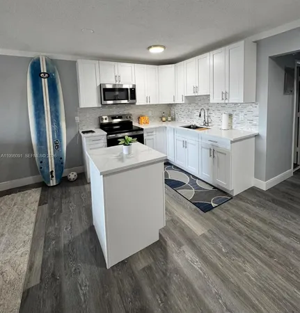 a kitchen with granite countertop a refrigerator stove top oven and sink