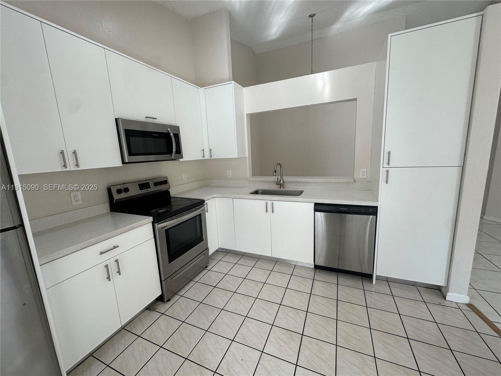 9336 Ketay Circle Boca Raton, FL 33428 - Photo 16 of 48 a kitchen with a stove a sink and a refrigerator