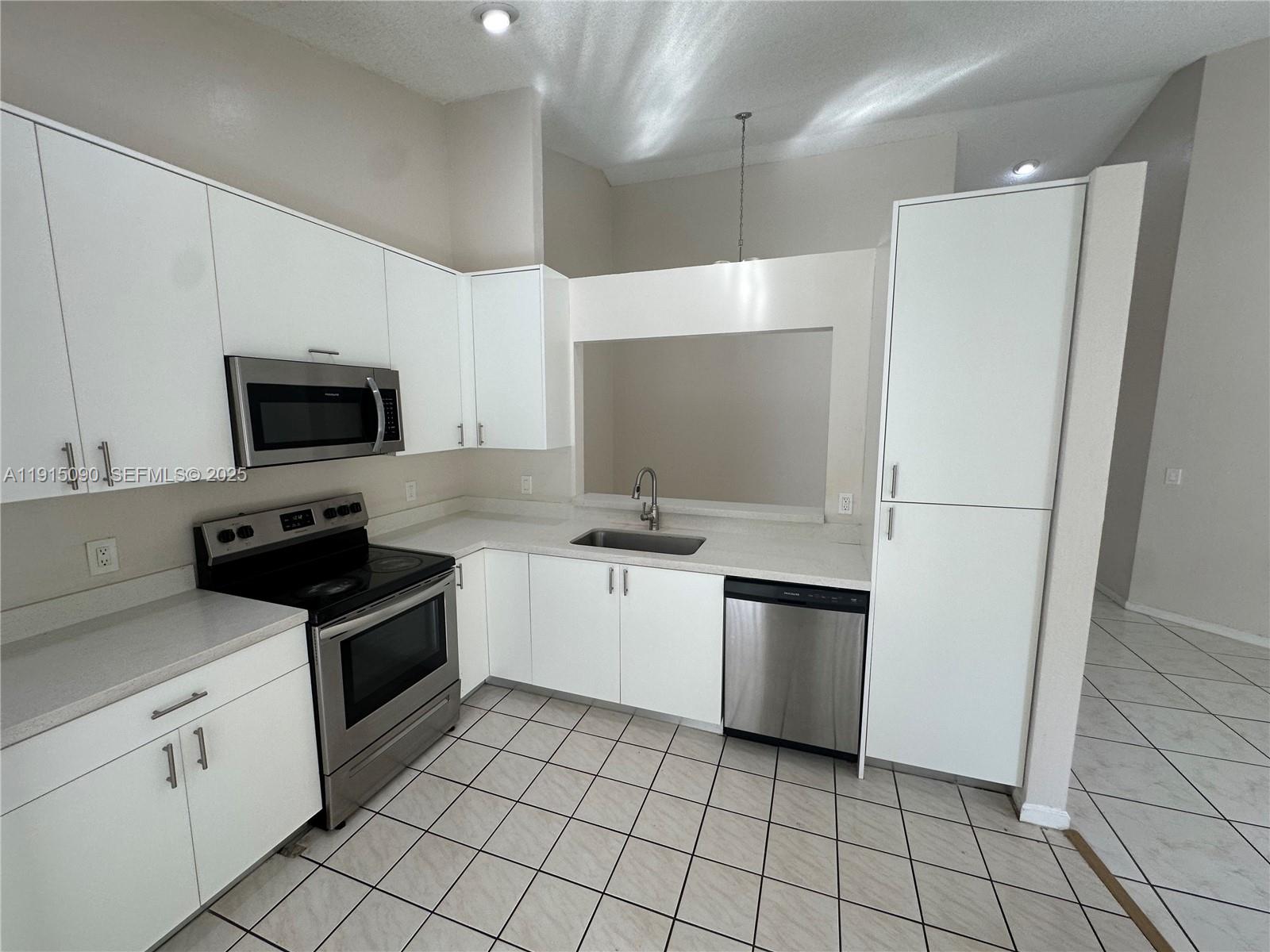 9336 Ketay Circle Boca Raton, FL 33428 - Photo 17 of 48 a kitchen with a sink a stove top oven and cabinets