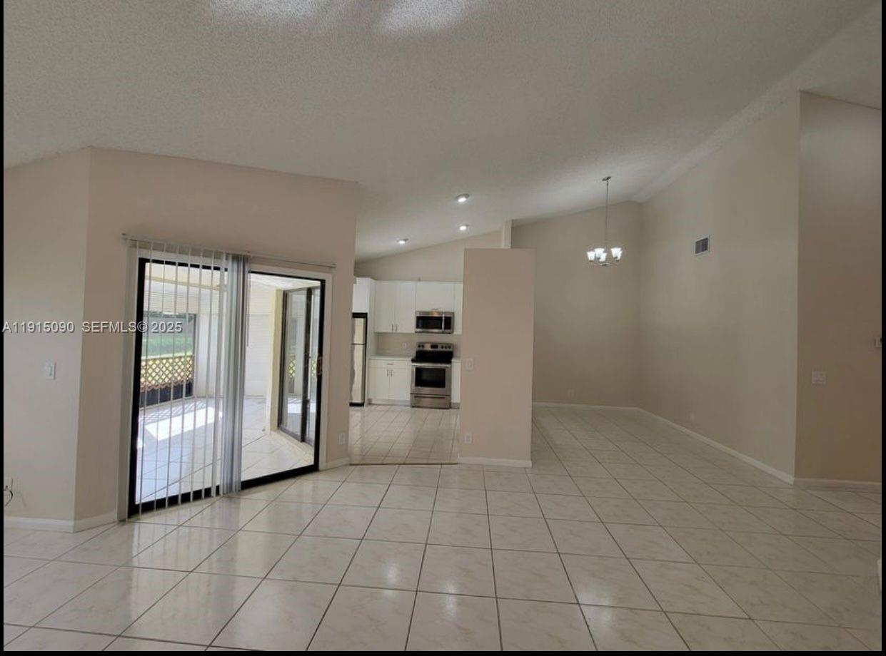 9336 Ketay Circle Boca Raton, FL 33428 - Photo 18 of 48 a view of an empty room with a kitchen