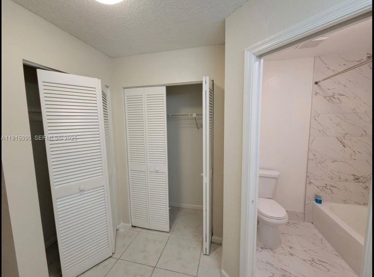 9336 Ketay Circle Boca Raton, FL 33428 - Photo 30 of 48 a bathroom with a granite countertop toilet a sink and a bathtub