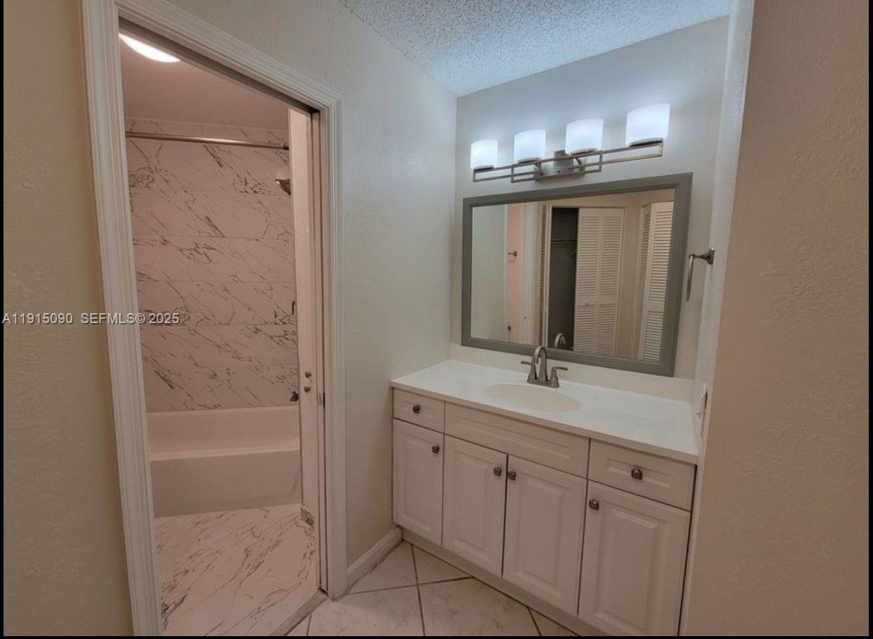 9336 Ketay Circle Boca Raton, FL 33428 - Photo 31 of 48 a bathroom with a granite countertop sink a mirror and a bathtub