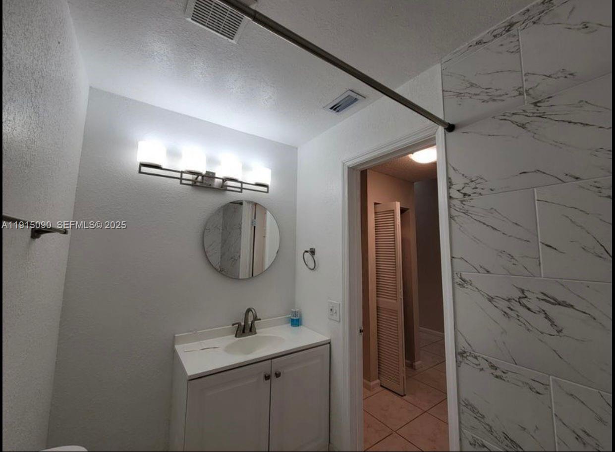 9336 Ketay Circle Boca Raton, FL 33428 - Photo 37 of 48 a bathroom with a shower a sink and mirror