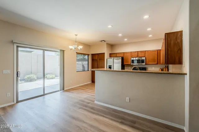 a view of kitchen with refrigerator cabinets and wooden floor