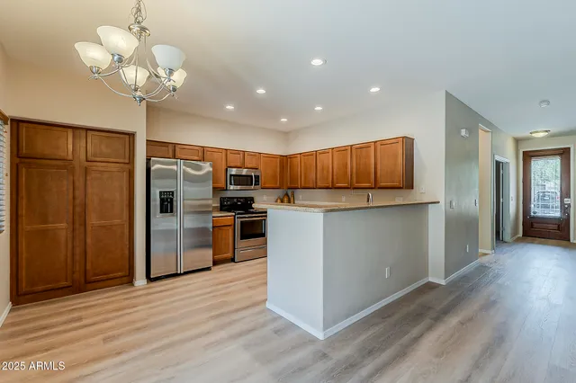 a kitchen with stainless steel appliances granite countertop a refrigerator and a stove top oven