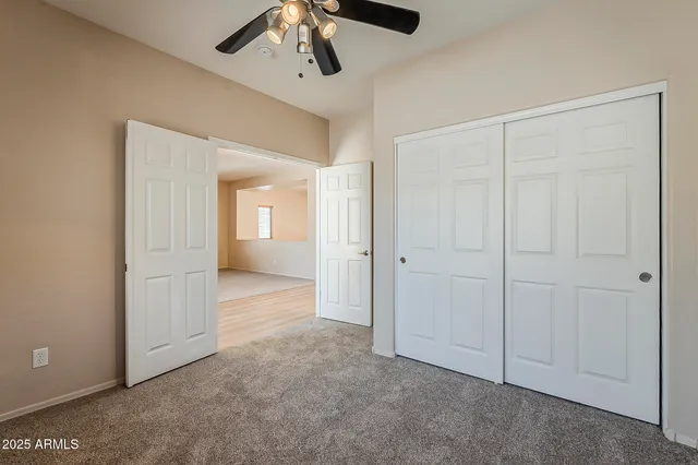 an empty room with fan and entrance