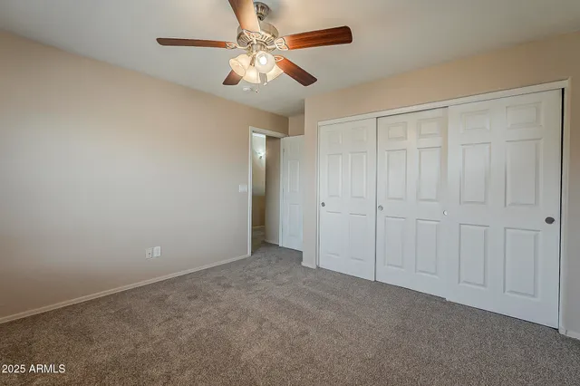 an empty room with chandelier fan