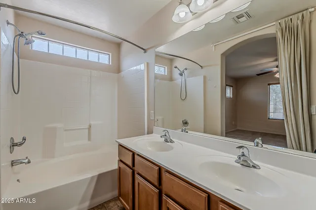 a bathroom with a bathtub shower sink and a mirror