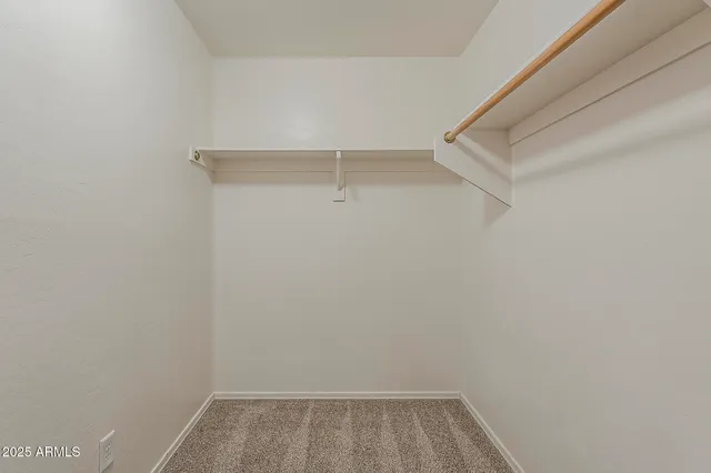 a view of walk in closet with empty racks