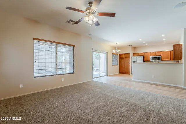 a view of a kitchen with a stove cabinets a ceiling fan and wooden floor