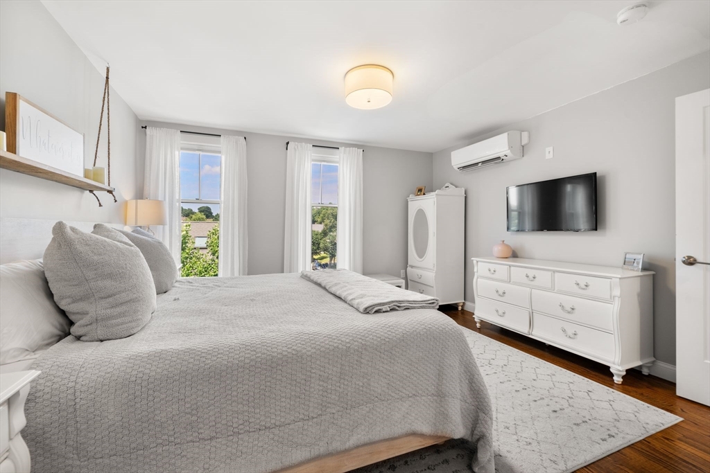 1789 Centre Street, Unit 401 Boston, MA 02132 - Photo 13 of 30 a bedroom with a bed and flat screen tv