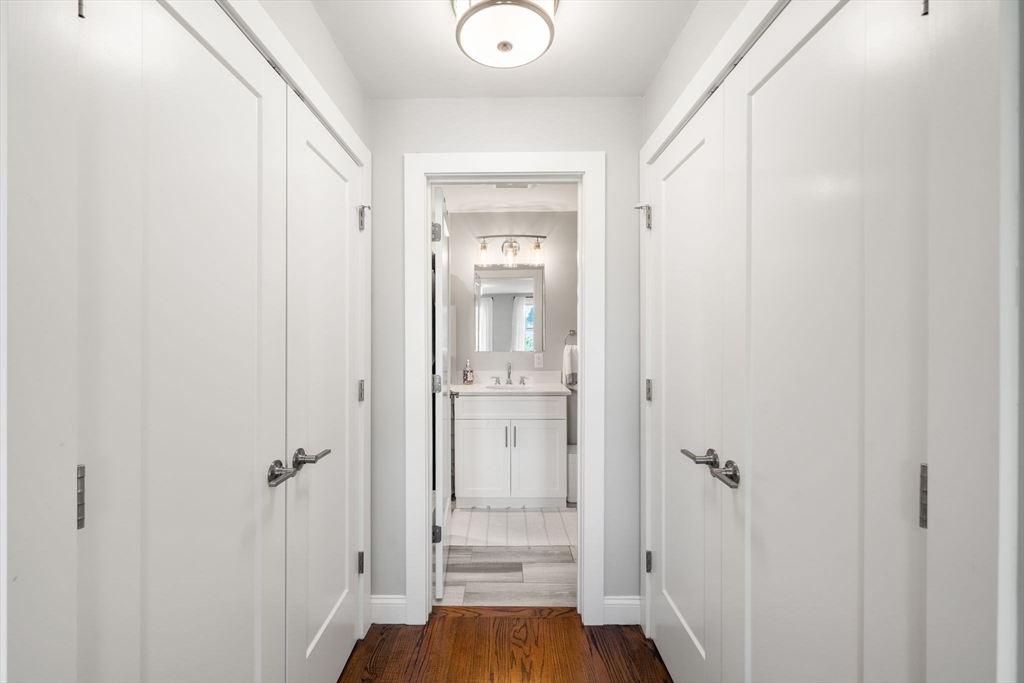 1789 Centre Street, Unit 401 Boston, MA 02132 - Photo 14 of 30 a view of a hallway with wooden floor and a bathroom